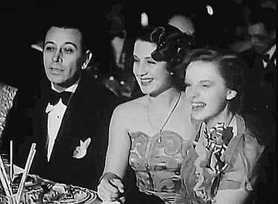 cadams46:  I don’t know what she’s doing or who she’s talking to but it’s absolutely adorable. <3 At the 1940 Academy Awards.  