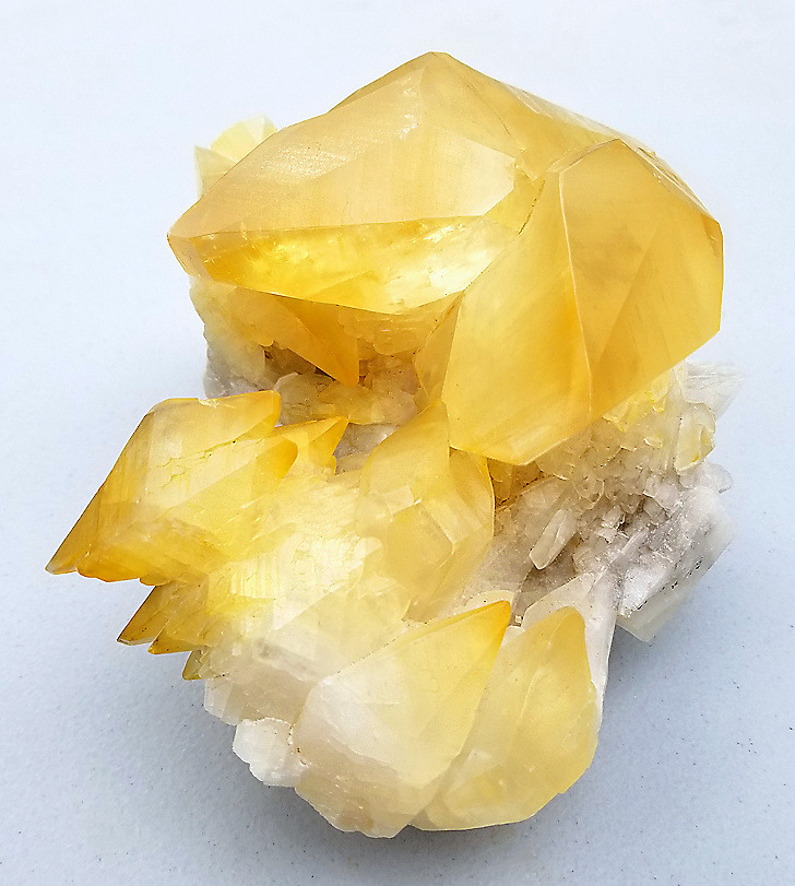 hematitehearts:    Golden Calcite crystals in cluster atop white Calcite  Locality: 