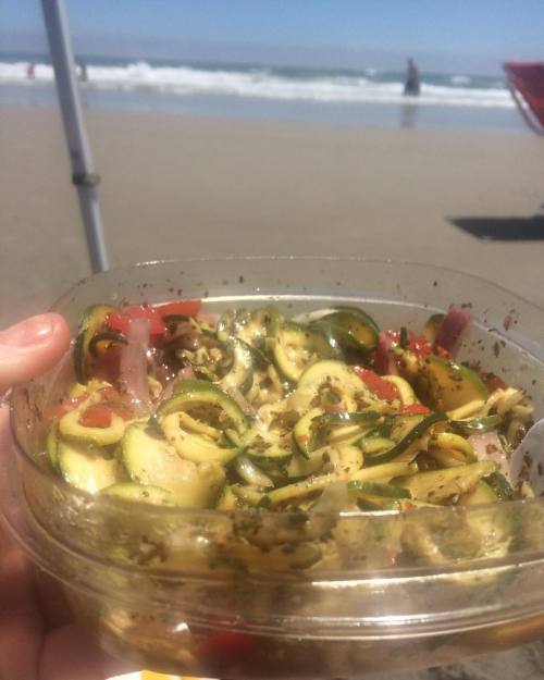 Homemade zesty Italian “Zoodle” salad with onions and cherry tomatoes for a snack on the