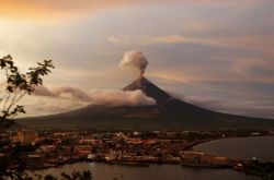Fotojournalismus: The Mayon Volcano Spews Ash As The Sun Sets Behind Legazpi City