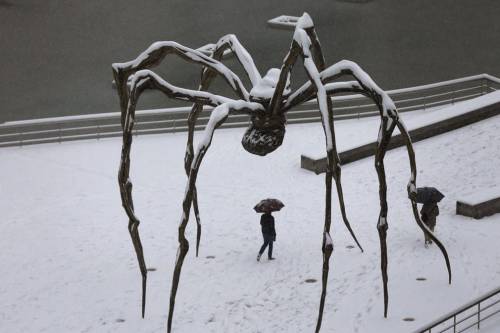 ruckawriter: Photo: Bilbao, Spain  A man walks under a snow-covered sculpture by Louise Bourgeois in front of the Guggenheim museum.  Photograph: Luis Tejido/EPA, found at The Guardian. 