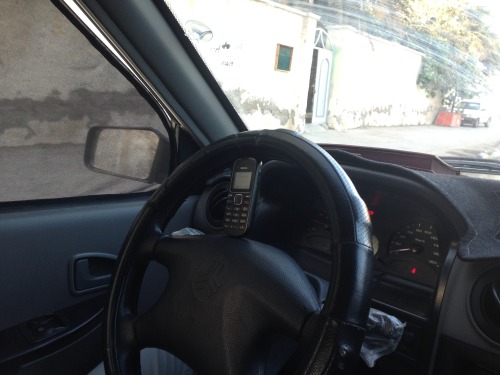 Nokia mobile phone of an creative cab driver fitting perfectly into the steering wheel.Bandar Abbas,
