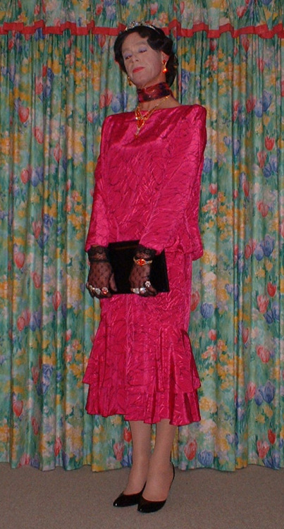 A lovely pink satin dress with flounced skirt. Lacy gloves a black handbag and shoes diamante jewell