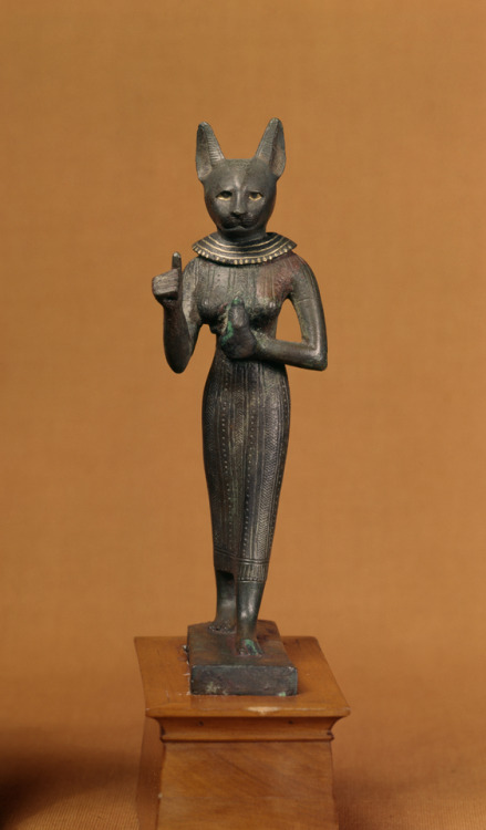 Standing statuette (bronze with gold inlay) of the ancient Egyptian cat-goddess Bastet, holding an u