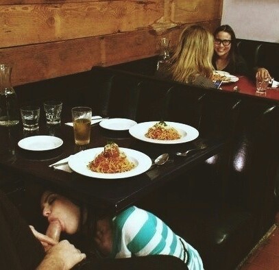 Foto de una mamada bajo la mesa del restaurante.
