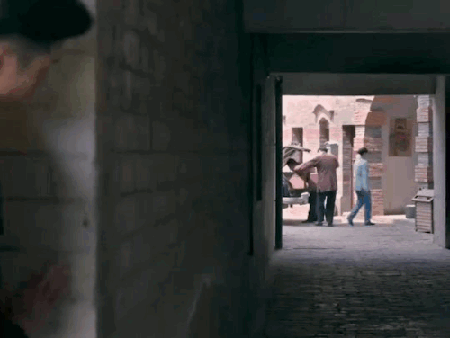 chusheng peeking from behind a wall, lu yao moving behind him and putting a hand on his shoulder