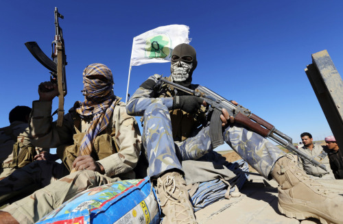 Masked Shi'ite fighters hold their weapons in Al Hadidiya, south of Tikrit, en route to the Islamic 