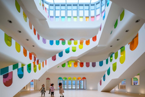 itscolossal:Hundreds of Rainbow Glass Panels Emit a Rotating Kaleidoscope in a Playful Kindergarten