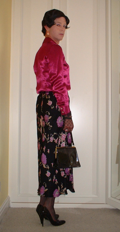 A lovely silky mauve blouse with black floral patterned skirt and patent stiletto and handbag.