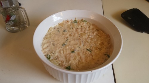 a round baking dish filled with an overly moist mixture of cream, bread crumbs, onion, and green peppers