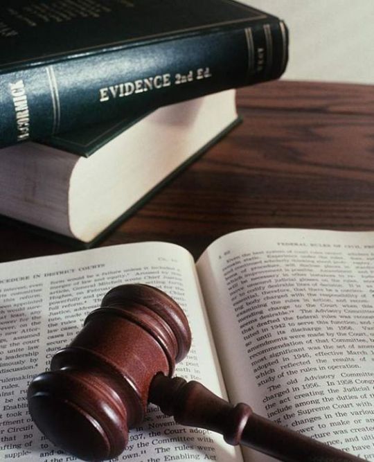 An image of two books in a stack with the top one having Evidence 2nd Edition (shorthand) on it next to an open book with a gavel on it