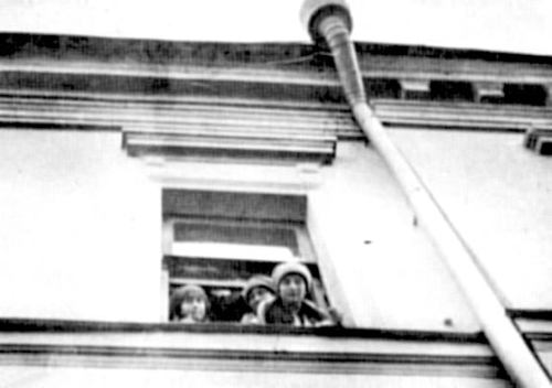 Grand Duchesses Marie, Anastasia and Tatiana Nikolaevna Romanov peering out a window in captivity.