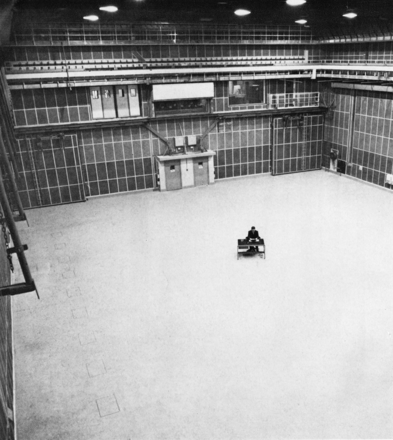 “Above: The starting point. This bare, empty studio (the TV Centre’s Studio 12) is ready for rigging up with the sets and lighting for a new programme. The solitary figure gives an idea of its huge size.
”