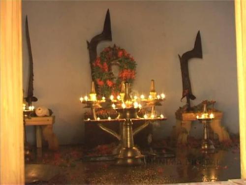 Theyyam shrine, the garlanded mirror and the swords represent de Goddess Bhagavati