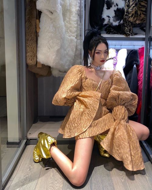 Feng Fan in Maison Margiela gold ankle booties. Dress by eth0s, bag by Vivienne Westwood 