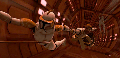 Cody and Obi-Wan dangle over a long drop. Cody is holding onto the wall with one hand, Obi-Wan is hanging off the other one. Below them another 212th clone is hanging off the wall. Air rushes past.