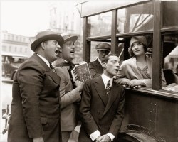 Marceline Day looking misty eyed, while Buster Keaton and director Edward Sedgwick serenade her in song on the set of the wonderful comedy film “The Cameraman” (1928)