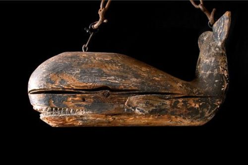 browndresswithwhitedots:whale sign, early 19th century                [ID: a battered wooden carved 