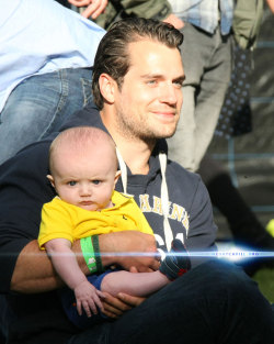 amancanfly:  Henry Cavill holding a baby at The Groove Music Festival in Bray, Ireland. Image via HCO.