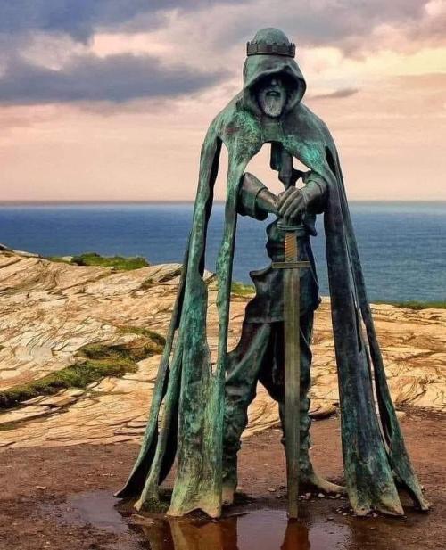 sixpenceee:An 8-foot Bronze statue of King Arthur overlooks the Atlantic Coast of Cornwall.         