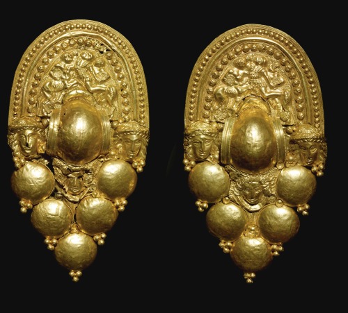Pair of gold Etruscan earrings depicting battling centaurs and warriors on the upper plaque sections