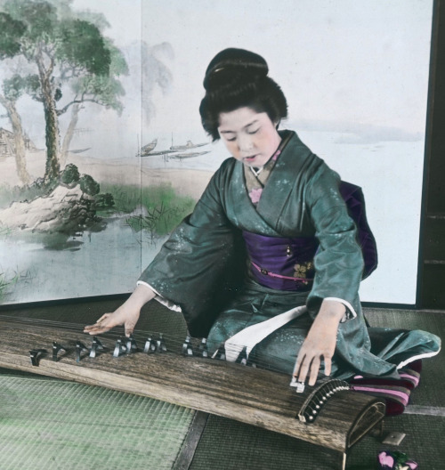 Hand-colored photo of a woman playing a &lsquo;koto&quot; (zither). Early 20th century 1900-1920, Ja