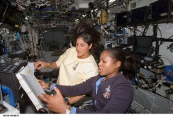 just–space:Building the Space Station : Astronauts Joan Higginbotham (foreground) and Suni Williams refer to a procedures checklist as they work the controls of the Canadarm2, in this 2006 image. (via NASA)