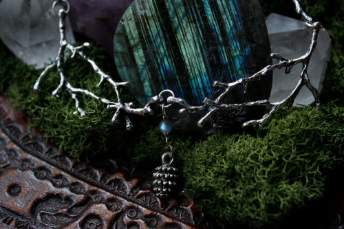 90377:this beautiful necklace is made of silver plated twigs, a bright blue/green labradorite bead a