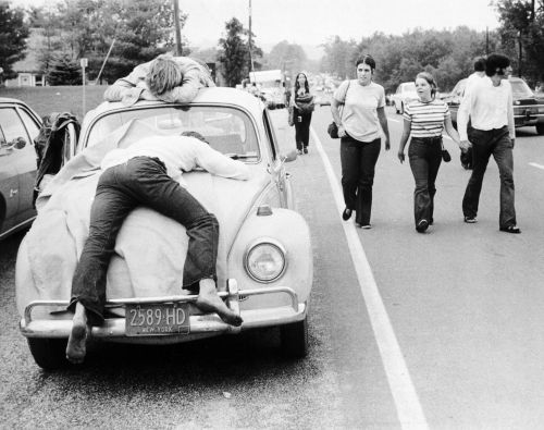 Woodstock festival goers lay passed out on their beetle. 1969.