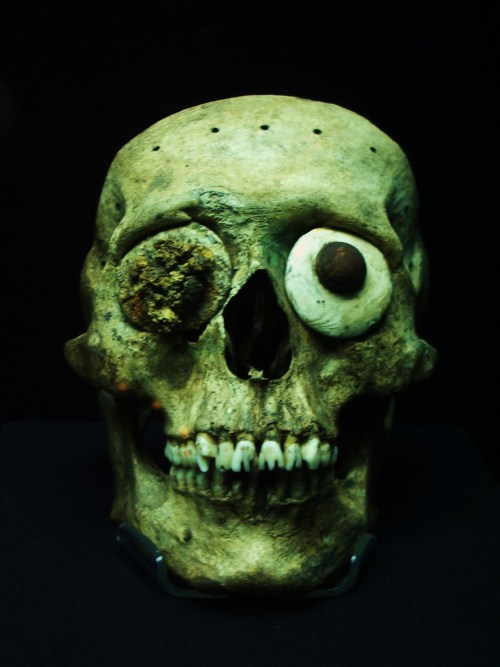 ancientart:Adorned Mexica skull mask, found at Great Pyramid of Tenochtitlán. This mask was made from the front section of an authentic human cranium, which has been fitted with discs made of pyrite and shell. Note also the incised teeth, and drilled