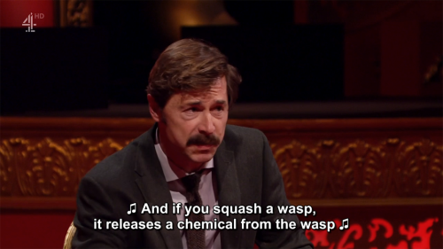 [ID: Two screencaps from Taskmaster. Mike Wozniak sings, “And if you squash a wasp, it release