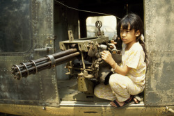 unrar:    Vietnamese girl at U.S. Army helicopter-mounted Gatlin gun, Paul Chesley.