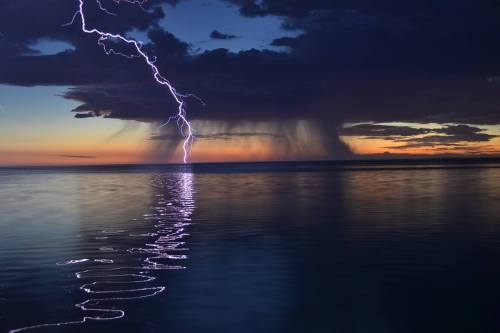 sixpenceee: Surreal lightning over a calm ocean. 