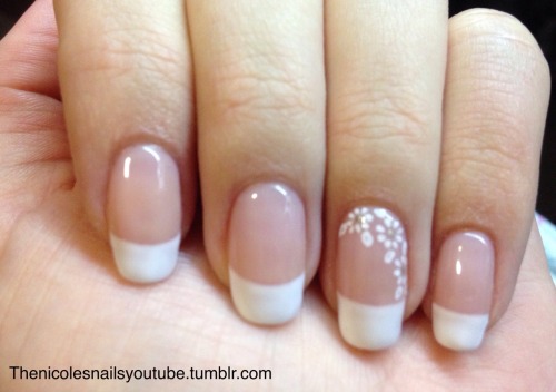 Subtle floral nail art on French manicure