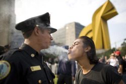 faccc:  A protester blows marijuana smoke against the face of a police officer during a march to mark the 1968 Tlatelolco plaza ‘massacre’ in Mexico City 