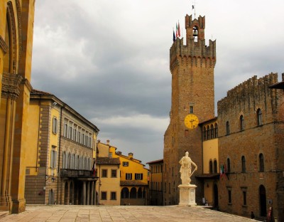 Lezersrubriek Going Back | Het centrum van het stadje Arezzo in oostelijk Toscane. Het is rustig. Een nagenoeg leeg plein. Het mooie van deze foto vind ik, afgezien van de prachtige middeleeuwse omgeving, dat - op de lucht na- alles in geel- en bruin...