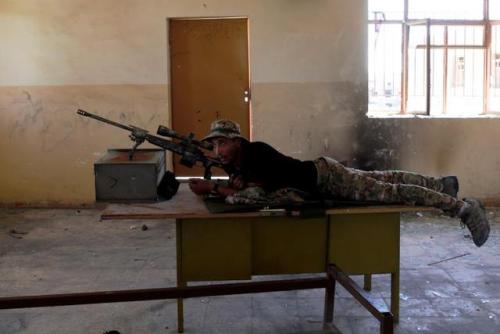 A sniper from the Iraqi Army aims at Islamic State positions from a school building on the frontline