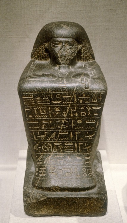 Inscribed block statue (black granite) of Irj-aa, a priest of Amun.  Artist unknown; ca. 750-664 BCE