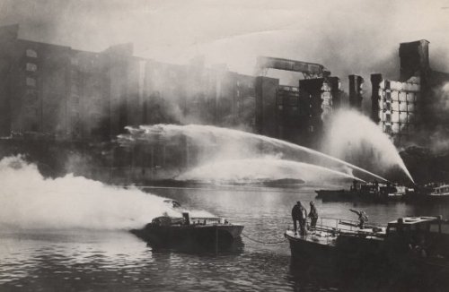 London firefighters direct water from their fireboats onto blazingwarehouses around the Eastern Basi