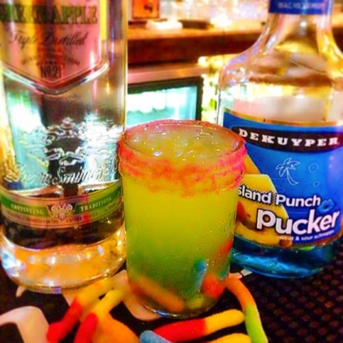 tipsybartender:  THE GLOW WORM  1 oz (30ml) Apple Vodka ¾ oz. (22ml) Blue Island Pucker 1 1/2 oz. (45ml) Sweet & Sour 1 1/2 oz. (45ml) Pineapple Juice Rim glass with colored sugar Add Sour Worms  #drinkporn #foodporn #cocktail #smirnoff #vodka