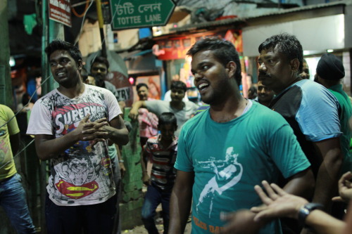 An anxious crowd gathers around one tiny television screen to catch the final minutes of the India -