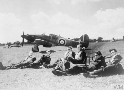 Pilots of &lsquo;B&rsquo; Flight, No. 32 Squadron, relax on the grass at RAFHawkinge in front of a H