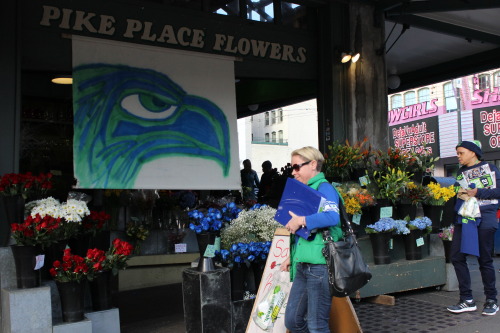 pikeplacemarketseattle:  Seahawks spirit was on full display Friday with produce sellers, craftspeople, shoppers and retailers showing their 12th Man pride.  Market merchants Quality Cheese, The Confectional, Pike Place Flowers, La Mexicana and others