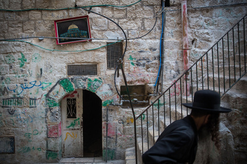 An Ultra Orthodox Jewish man walks past a picture of the Dome of the Rock, hung on a wall in the Mus