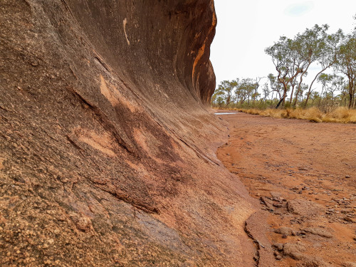 Wave rock around base of the Uluru monolith in Central Australia. An example of erosion-driven sculp