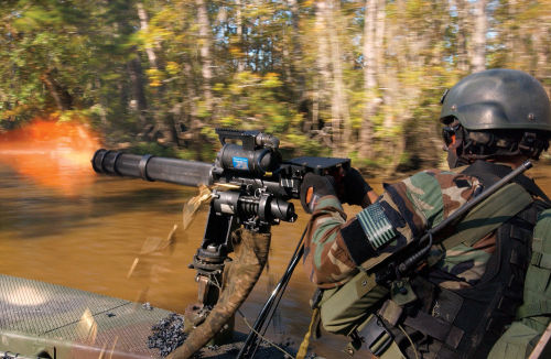 militaryarmament:  A Special warfare combatant-craft crewman using a Minigun to lay down suppressing fire during a practice hot extraction of forces on the beach. October 2, 2009.