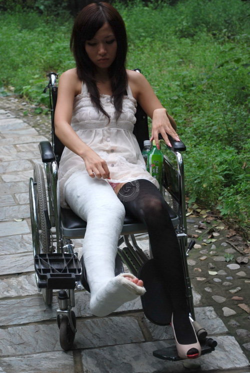 Poor girl with broken leg in wheelchair  adult photos