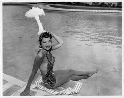 showgirl Linda Lawson, also known as Miss-Cue, at the Sands Hotel pool, wearing a mushroom cloud hea