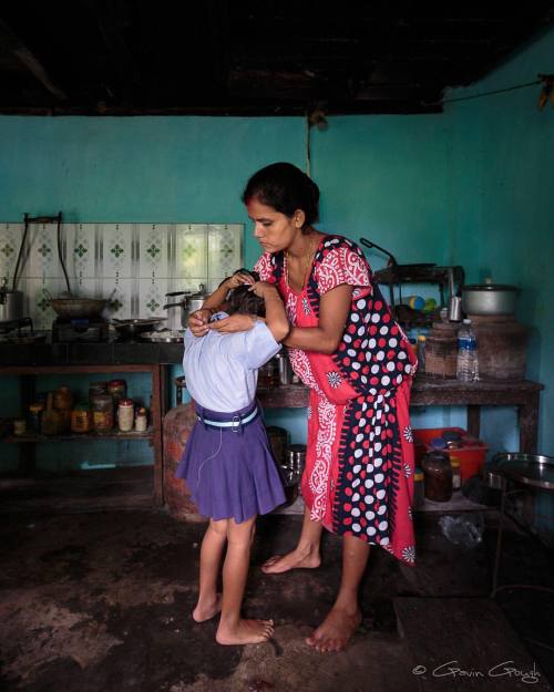 In the morning, Tara Dahal helps her daughter with her school...