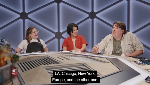 Jacob is saying, "LA, Chicago, New York, Europe, and the other one"